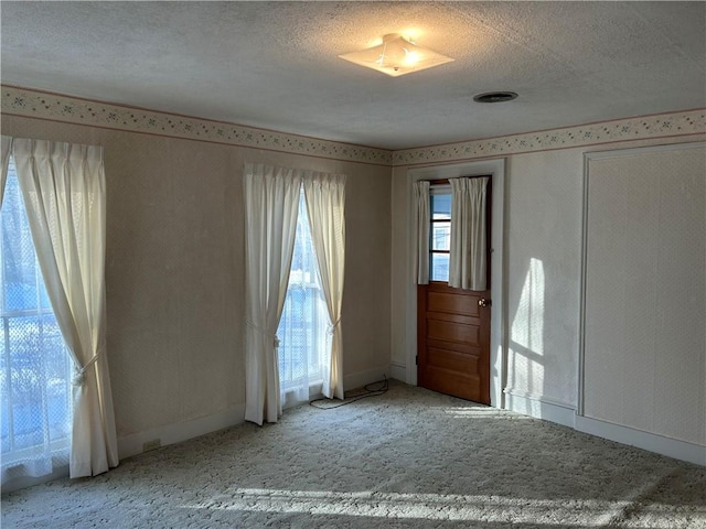 carpeted spare room with a textured ceiling