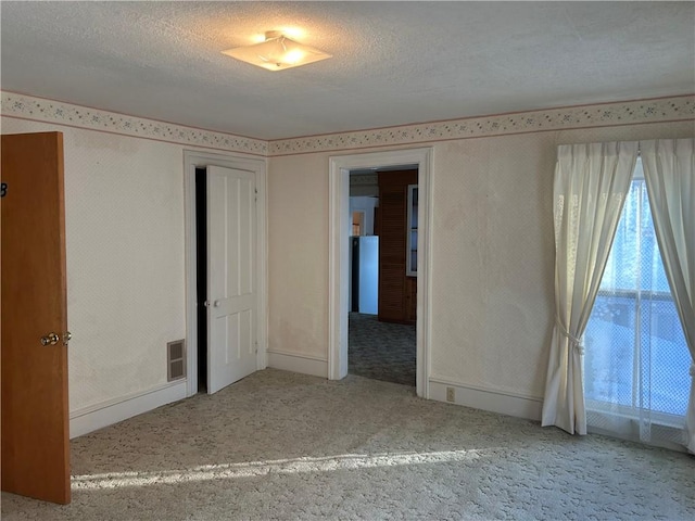 unfurnished bedroom with carpet flooring and a textured ceiling