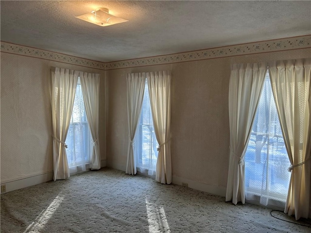 carpeted empty room featuring a textured ceiling