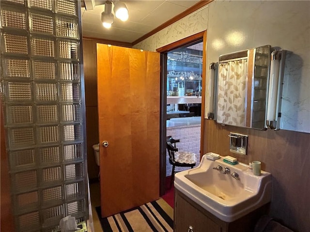 bathroom featuring crown molding, sink, walk in shower, and toilet