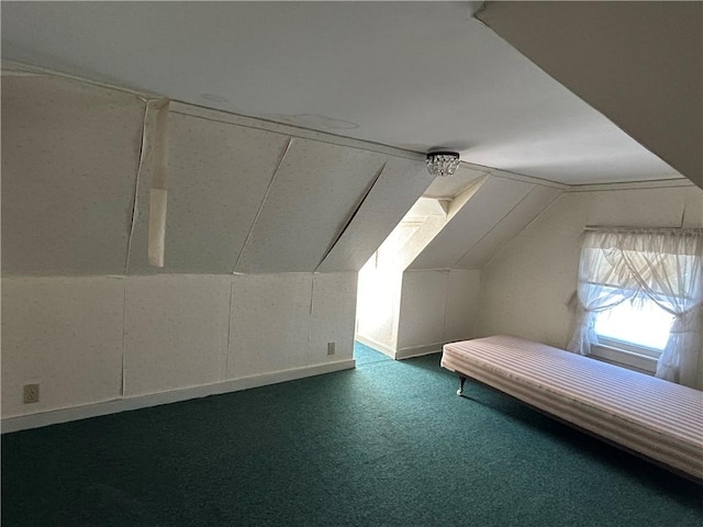 additional living space featuring vaulted ceiling and dark colored carpet