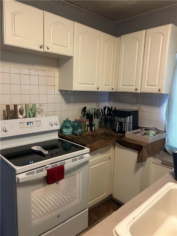 kitchen featuring white cabinetry, sink, tasteful backsplash, and white electric range oven