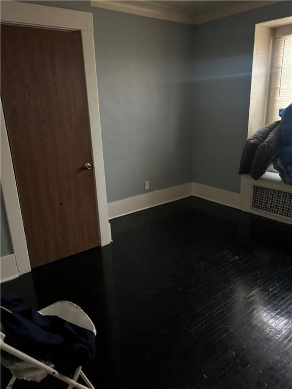 spare room featuring ornamental molding and dark hardwood / wood-style floors