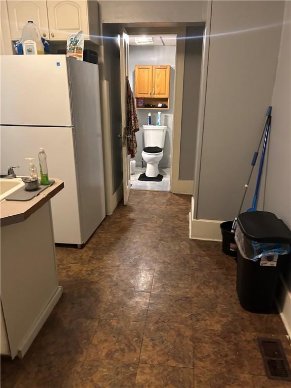 kitchen featuring white cabinets and white refrigerator