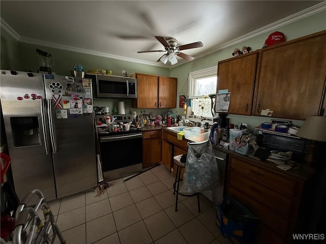 kitchen featuring sink, ornamental molding, light tile patterned flooring, and appliances with stainless steel finishes