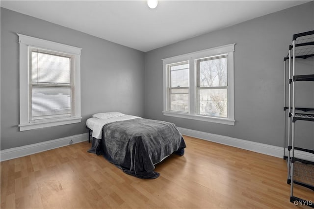 bedroom with multiple windows and light hardwood / wood-style flooring