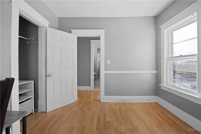 unfurnished bedroom with light wood-type flooring and a closet