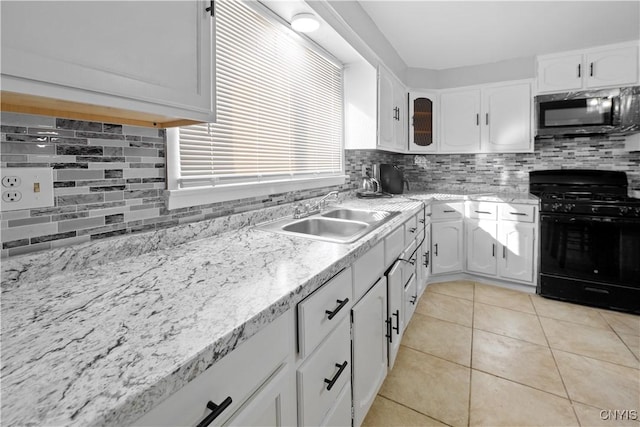 kitchen featuring white cabinetry, gas stove, sink, and backsplash