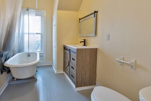 bathroom featuring vanity, toilet, vaulted ceiling, and a tub