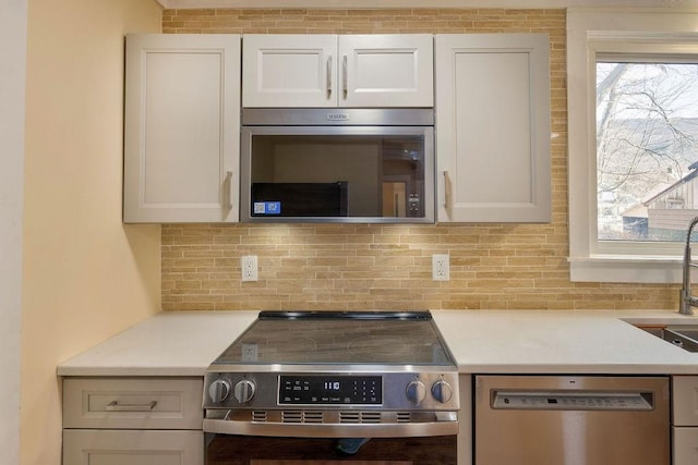 kitchen with white cabinetry, appliances with stainless steel finishes, and decorative backsplash