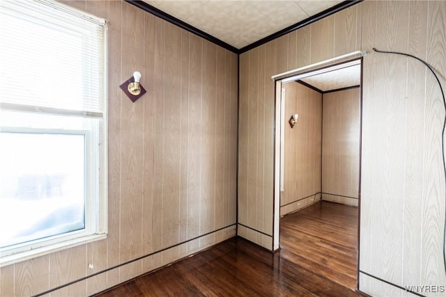 unfurnished room with dark wood-type flooring and wooden walls