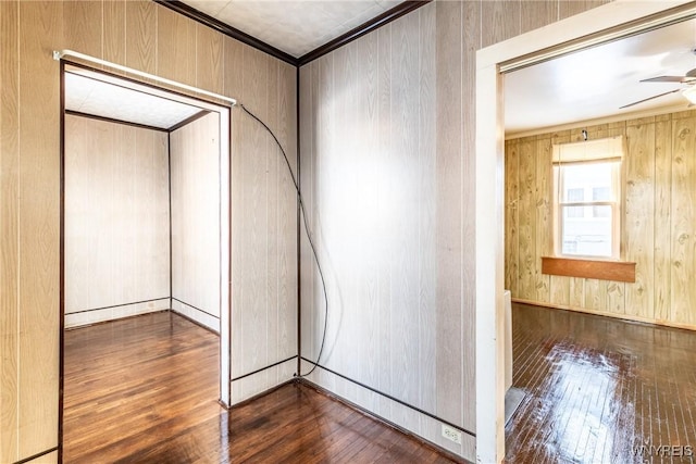 interior space featuring ornamental molding, dark wood-type flooring, and wood walls