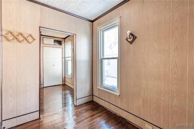 doorway to outside with hardwood / wood-style flooring, ornamental molding, and wood walls