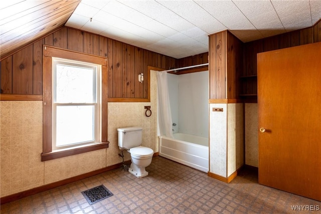 bathroom with vaulted ceiling, bathtub / shower combination, and toilet