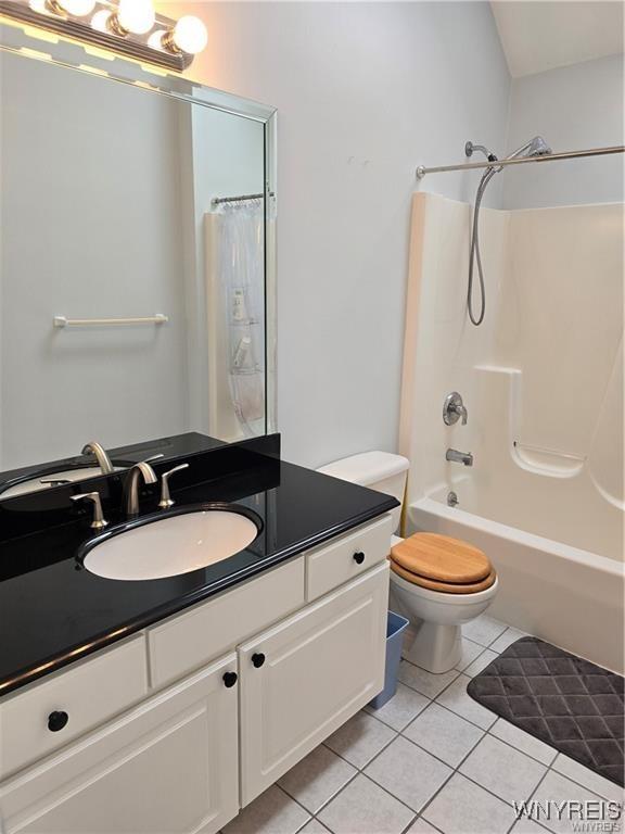 full bathroom with tile patterned flooring, vanity, toilet, and washtub / shower combination