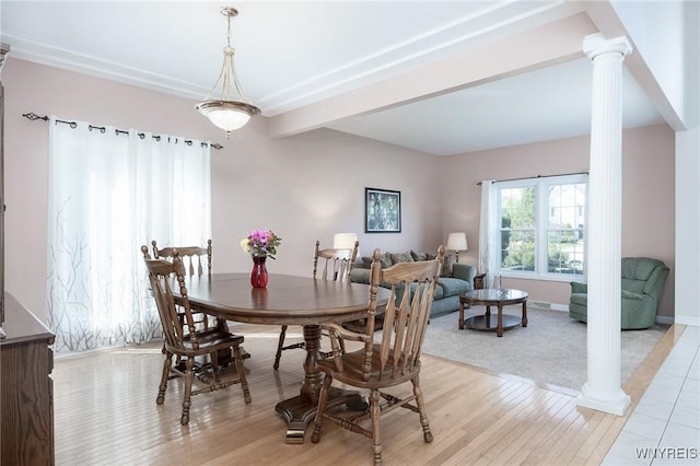 dining space featuring light hardwood / wood-style floors and decorative columns