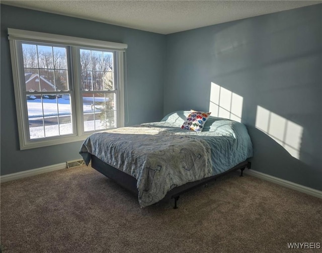 bedroom with carpet and a textured ceiling