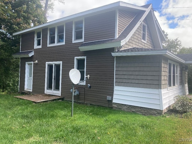 rear view of house featuring a lawn