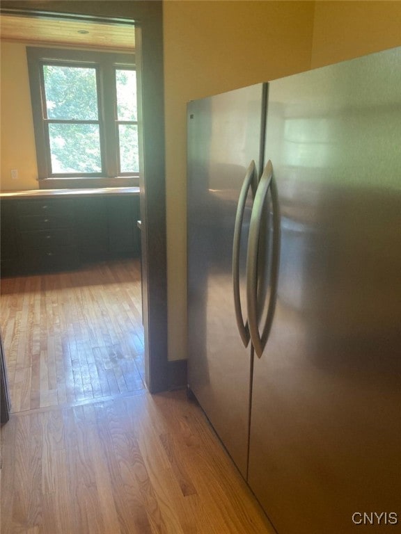 kitchen with stainless steel fridge and light hardwood / wood-style floors