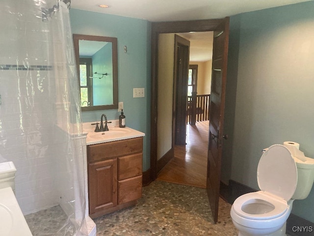 bathroom with vanity, curtained shower, and toilet