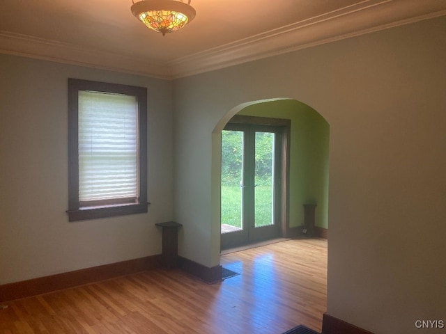 empty room with ornamental molding and light hardwood / wood-style floors