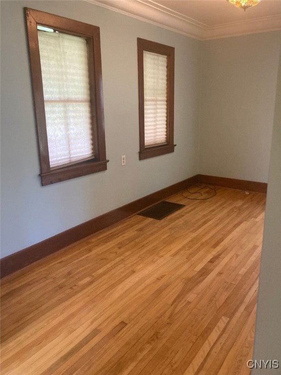 empty room featuring ornamental molding and light hardwood / wood-style flooring