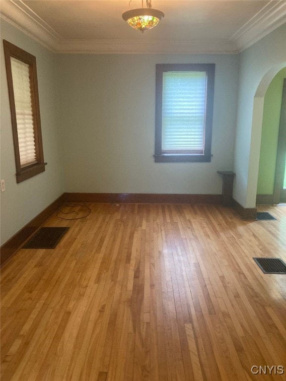 unfurnished room with crown molding, light hardwood / wood-style floors, and a healthy amount of sunlight