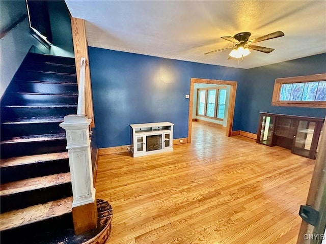 living room with ceiling fan and light hardwood / wood-style flooring