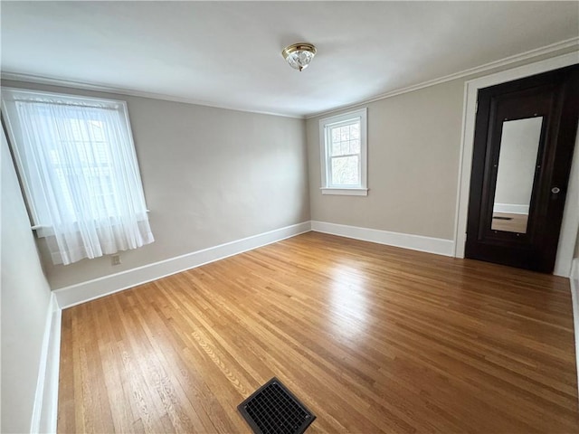 empty room with hardwood / wood-style flooring and ornamental molding