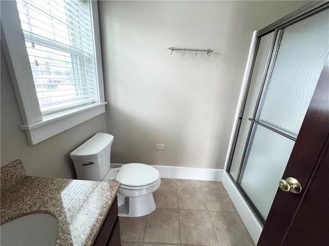 bathroom with tile patterned flooring, vanity, a shower with door, and toilet