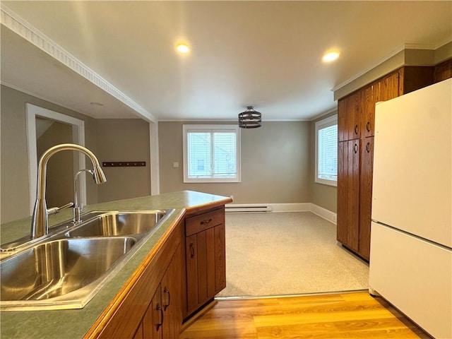 kitchen with ornamental molding, white fridge, sink, and a wealth of natural light