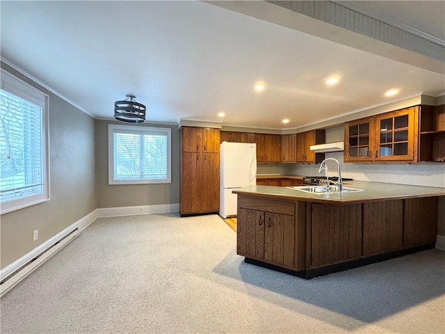 kitchen featuring sink, white fridge, a baseboard heating unit, kitchen peninsula, and crown molding