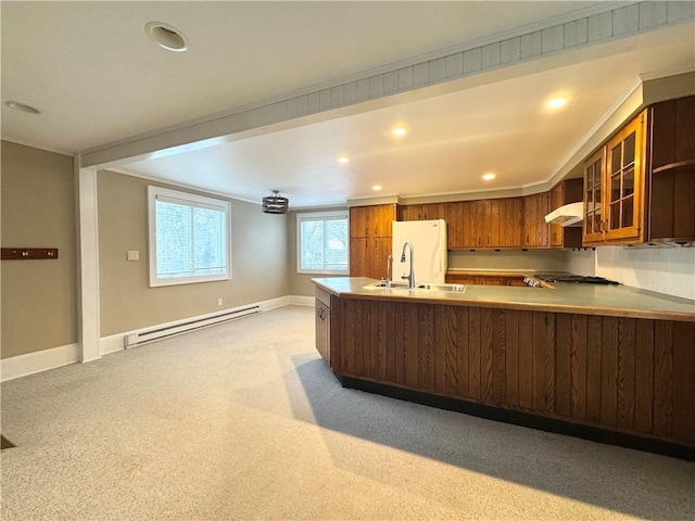 kitchen with ventilation hood, sink, fridge, baseboard heating, and kitchen peninsula