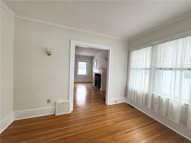 spare room featuring hardwood / wood-style flooring and ornamental molding