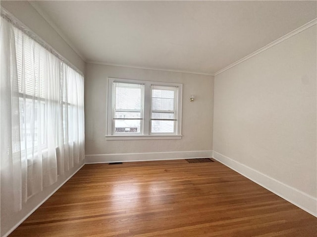 spare room with crown molding and hardwood / wood-style floors