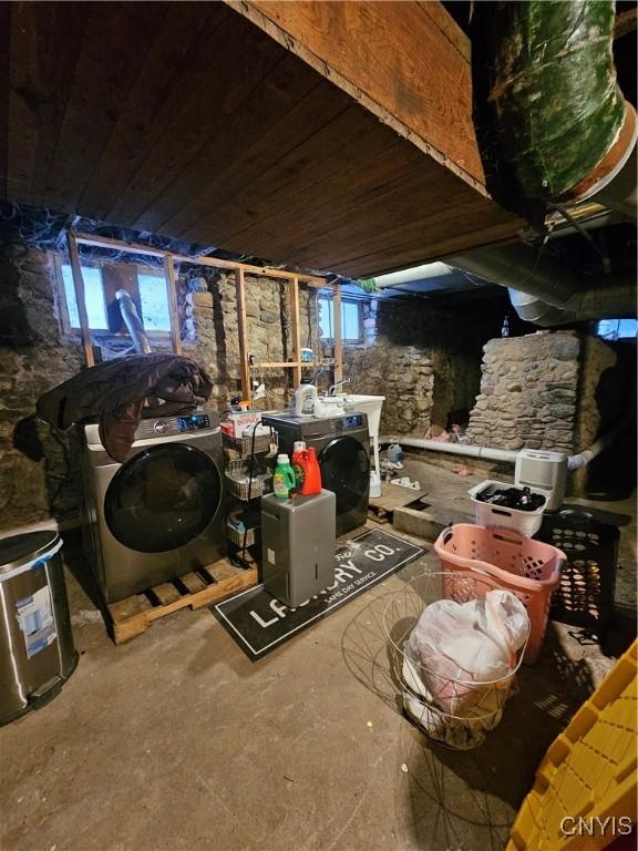 misc room with concrete flooring, wood ceiling, and washing machine and dryer