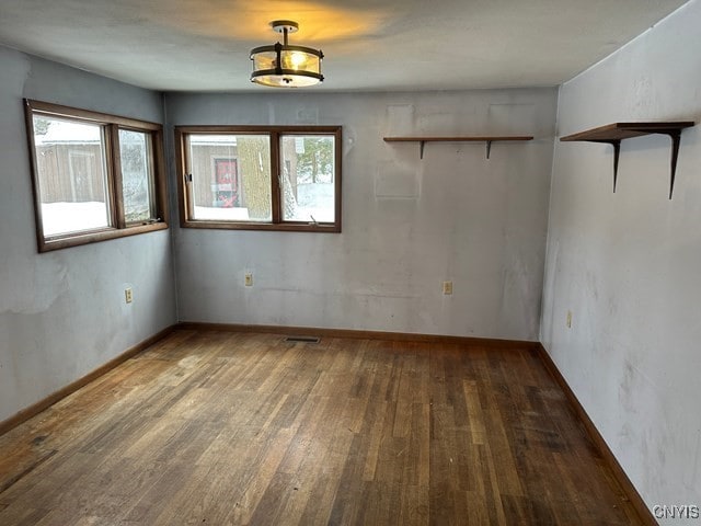 unfurnished room with plenty of natural light and dark wood-type flooring