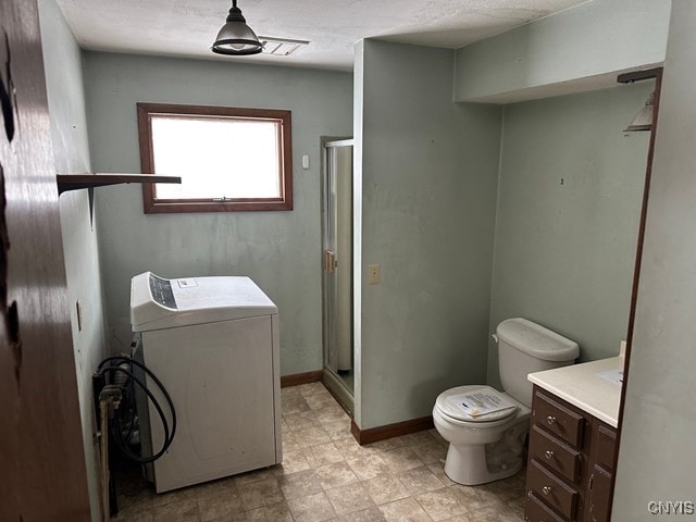 bathroom featuring vanity, a textured ceiling, washer / dryer, toilet, and walk in shower