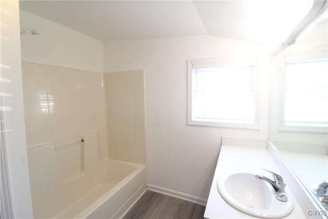 bathroom with vanity, wood-type flooring, shower / tub combination, and vaulted ceiling