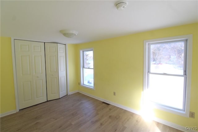 unfurnished bedroom with a closet and light hardwood / wood-style flooring