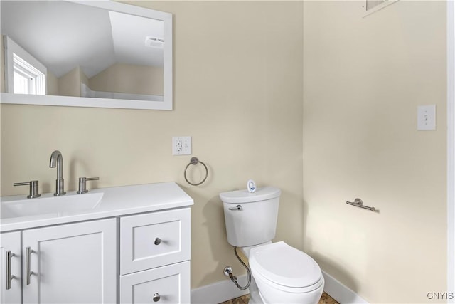 bathroom with vanity, toilet, and vaulted ceiling