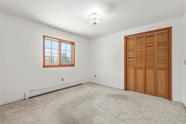 unfurnished bedroom featuring a baseboard radiator, light carpet, and a closet