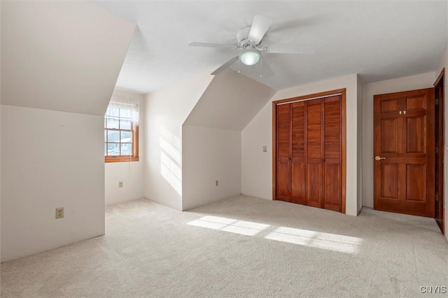 additional living space featuring vaulted ceiling, light colored carpet, and ceiling fan