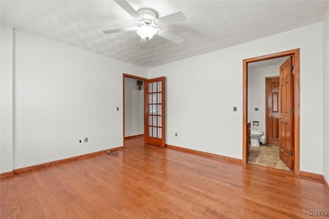 spare room with ceiling fan and light wood-type flooring