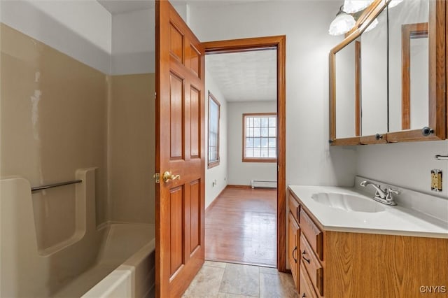 bathroom featuring baseboard heating and vanity