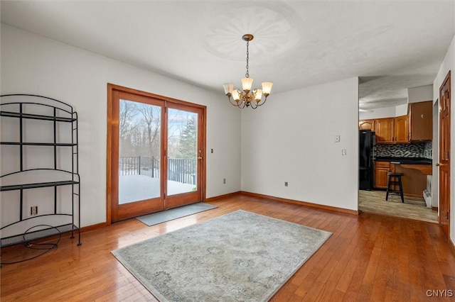 entryway with light wood-type flooring and a chandelier