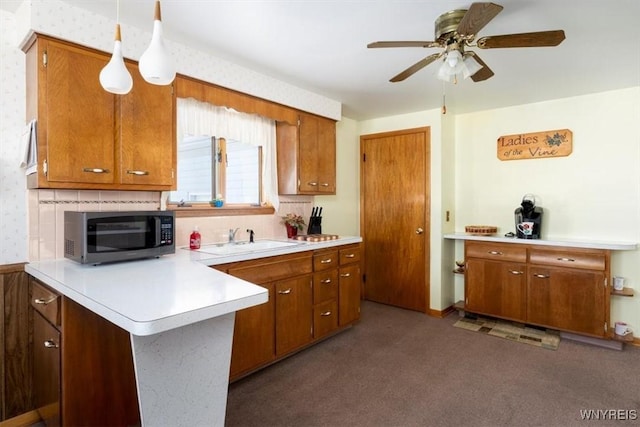 kitchen featuring hanging light fixtures, tasteful backsplash, sink, and ceiling fan