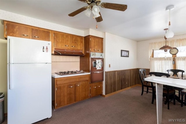 kitchen with ceiling fan, hanging light fixtures, stainless steel gas cooktop, dark carpet, and white fridge