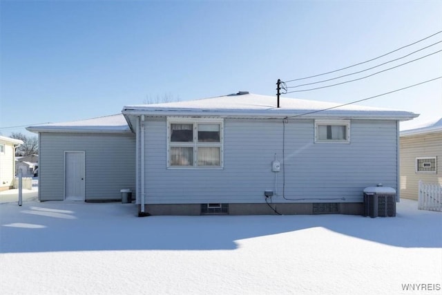 snow covered property with central AC