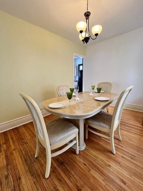 dining room with an inviting chandelier and light hardwood / wood-style flooring